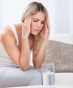Woman experiencing headache symptoms often linked to parasites, Lyme disease and biofilms